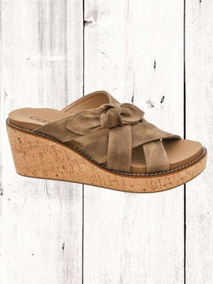 A pair of Corkys(*15) Bowdacious wedge sandals with multicolored straps and cork wedge heel, displayed against a wooden background.