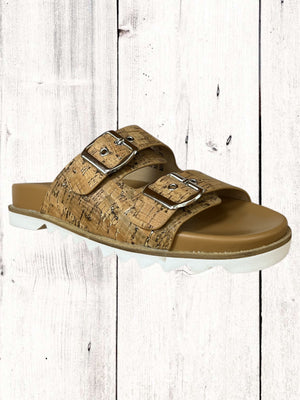 An image featuring a pair of black Corkys Dash sandals with adjustable buckles and a flat sole, displayed against a wooden background.