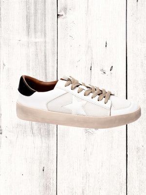 A sneaker with white sequins and star detailing, red laces, and a beige sole.