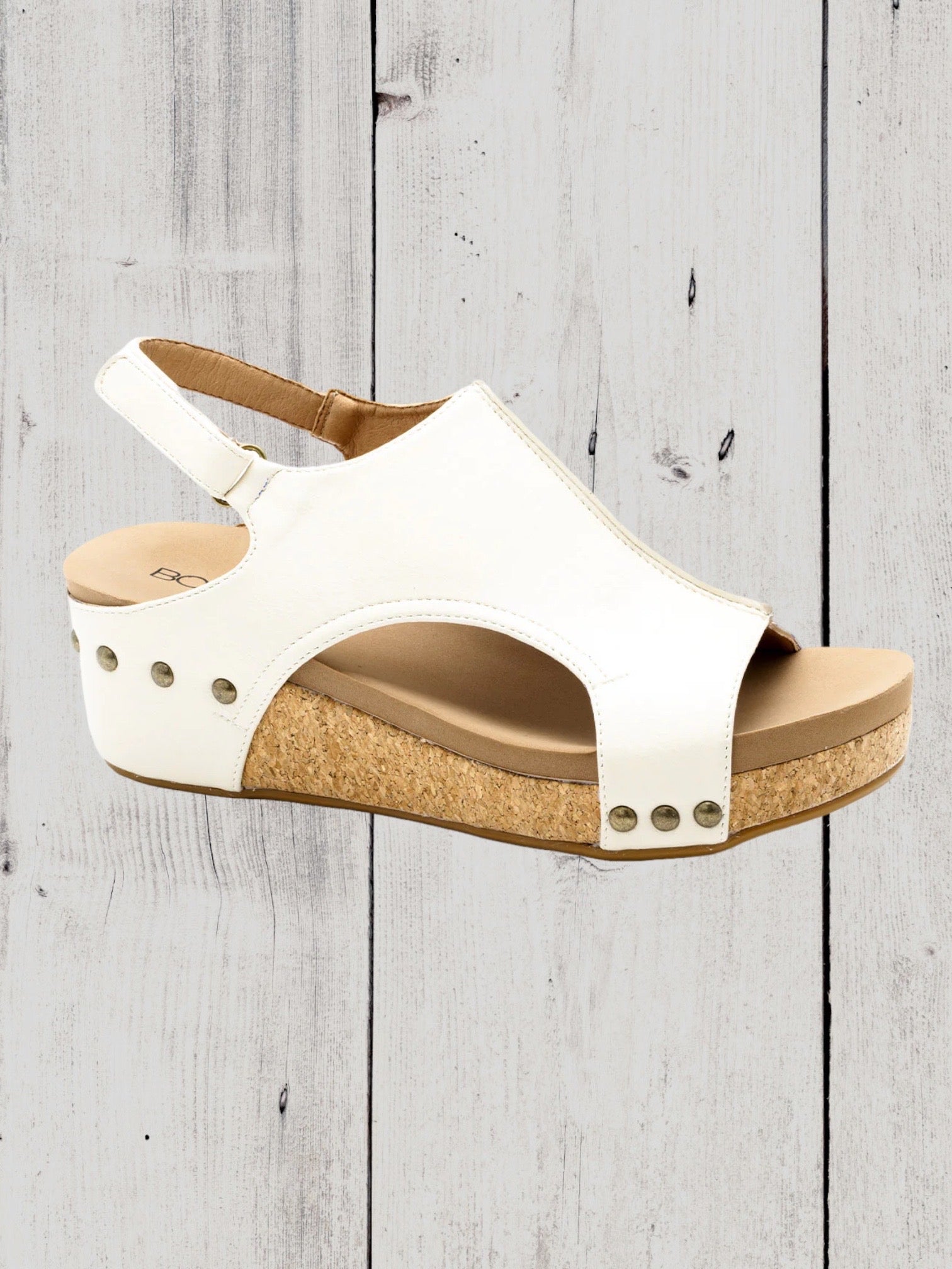 A black Corkys Volta II wedge sandal with a faux leather upper and cork wedge heel, featuring a hook and loop closure and studs on the heel.