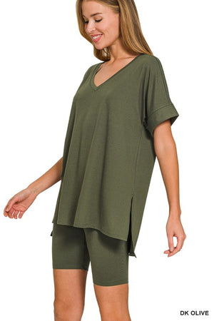 Woman wearing a green oversized t-shirt and shorts set on a white background