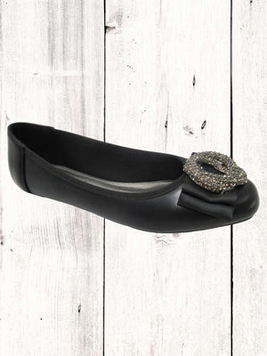 A black flat with a synthetic upper and a decorative buckle on the toe.