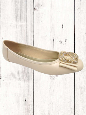 A black flat with a synthetic upper and a decorative flower brooch on the pointed toe. It is designed with a slip-on style and a padded footbed.