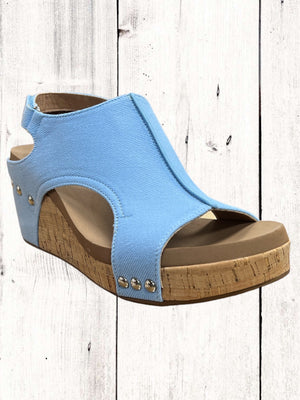 Blue wedge sandal with cork sole on a wooden floor