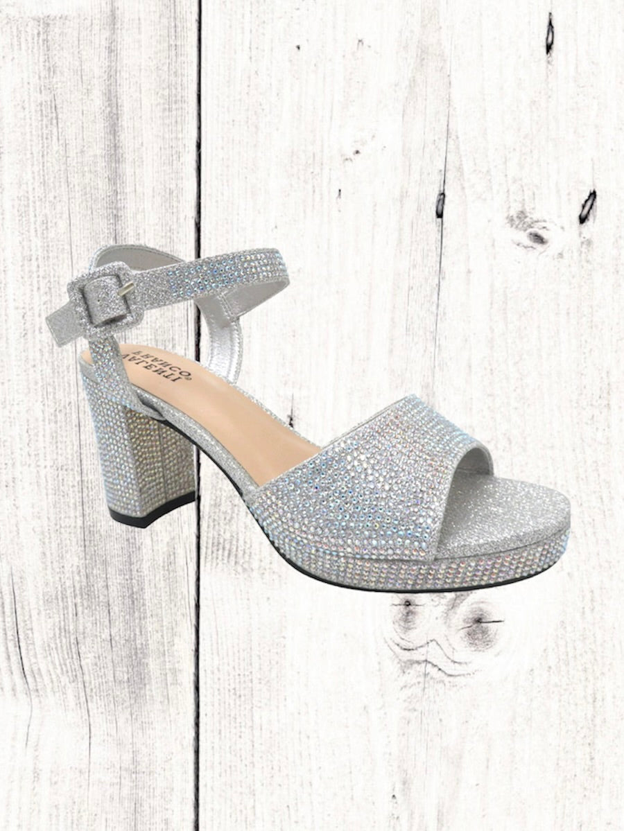 A black heel with a rhinestone design on the heel, featuring a one-strap design across the toe and an adjustable ankle strap on a white wooden surface.