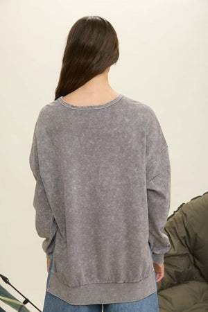 Person wearing a gray sweater with a neutral background