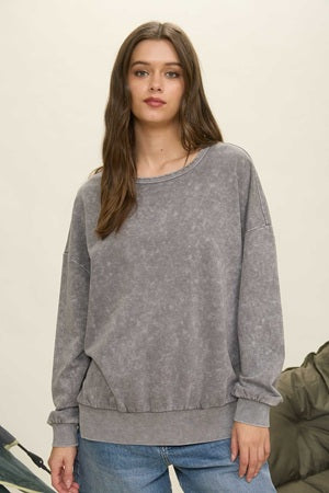 Woman wearing a gray sweater against a neutral background