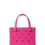 Pink handbag with black polka dots on a white background