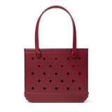 Maroon handbag with black polka dots on a white background