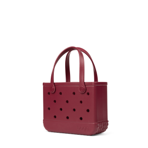 Maroon handbag with perforated design on a white background