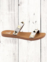 A black flat sandal with gold studs, featuring a comfortable fit and a brown sole.
