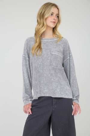 Woman wearing a gray sweater with a pocket on a white background