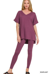 Woman wearing an eggplant-colored outfit on a white background