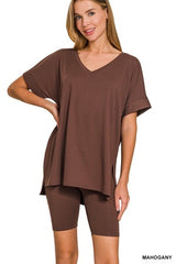 Woman wearing a brown oversized t-shirt and shorts set on a white background