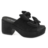 Black suede platform shoe with bow detail on a white background