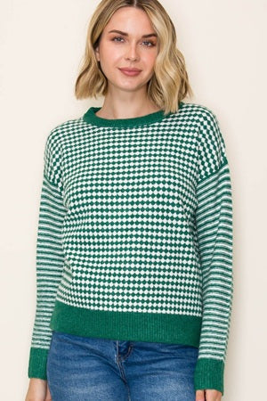 Woman wearing a green and white checkered sweater against a plain background
