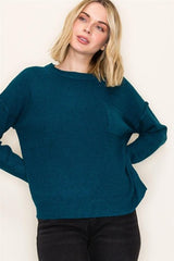 Woman wearing a teal sweater against a white background