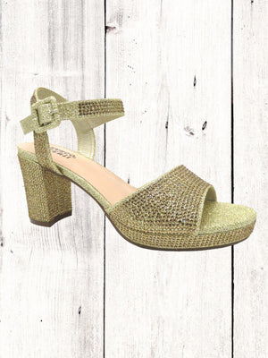 A black heel with a rhinestone design on the heel, featuring a one-strap design across the toe and an adjustable ankle strap on a white wooden surface.