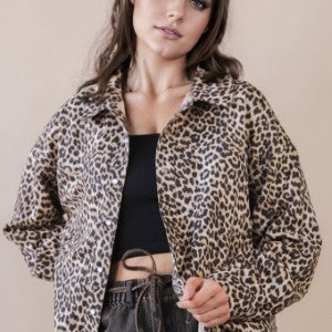 Woman wearing a leopard print jacket against a plain background