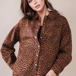 Person wearing a leopard print shirt against a plain background
