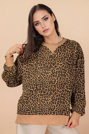 Woman wearing a leopard print sweater with a beige background