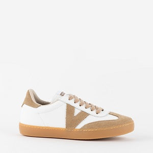White sneaker with tan accents on a white background