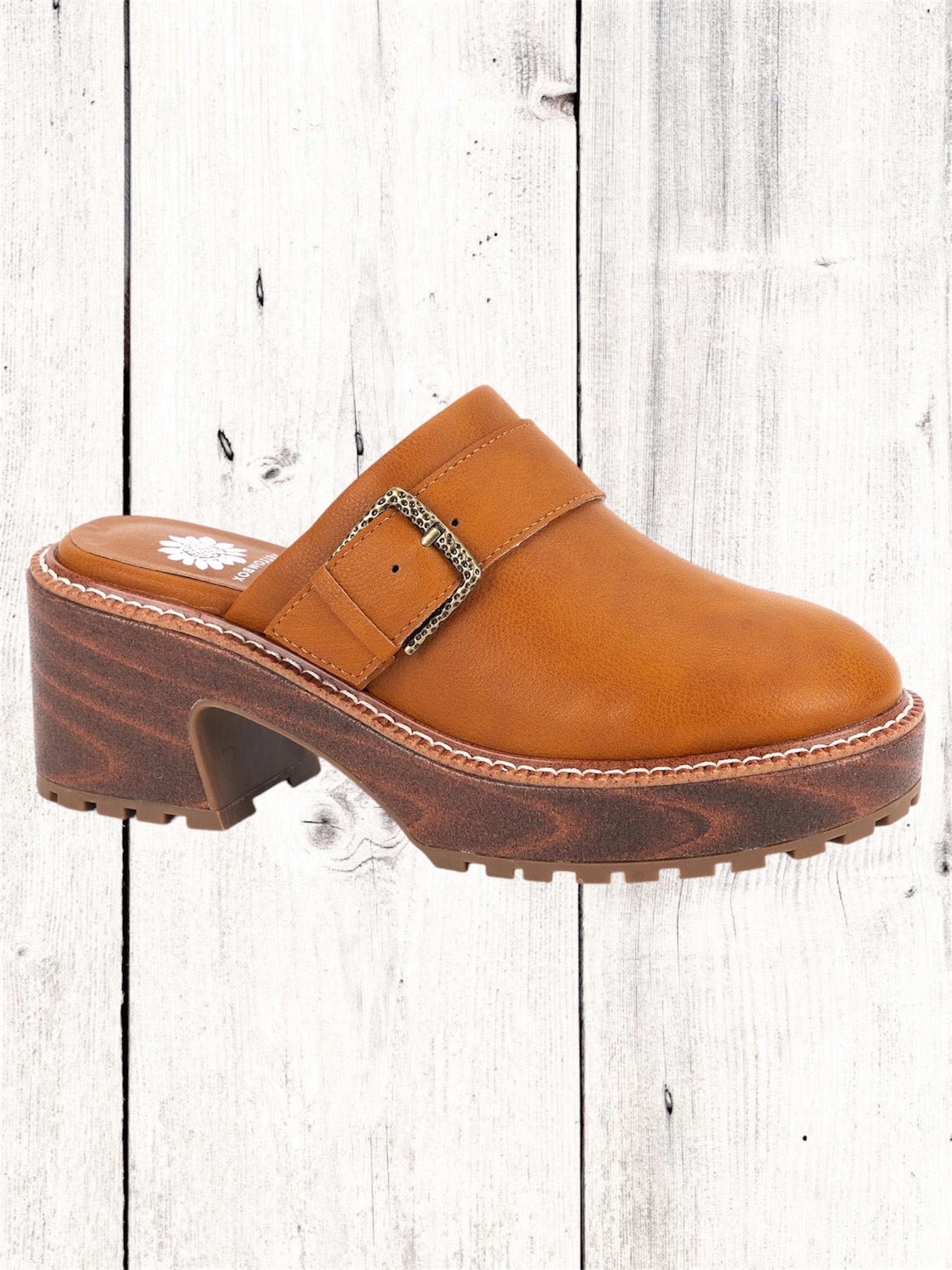 A black Yellow Box Barker Platform Clog with a wooden heel and a high rebound EVA footbed, displayed against a white wooden background.