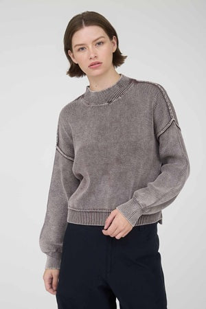 Woman wearing a gray sweater against a white background