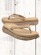 A pair of beige flip flops with a woven raffia upper and a low platform sole.