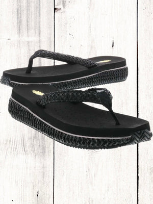 A pair of beige flip flops with a woven raffia upper and a low platform sole.